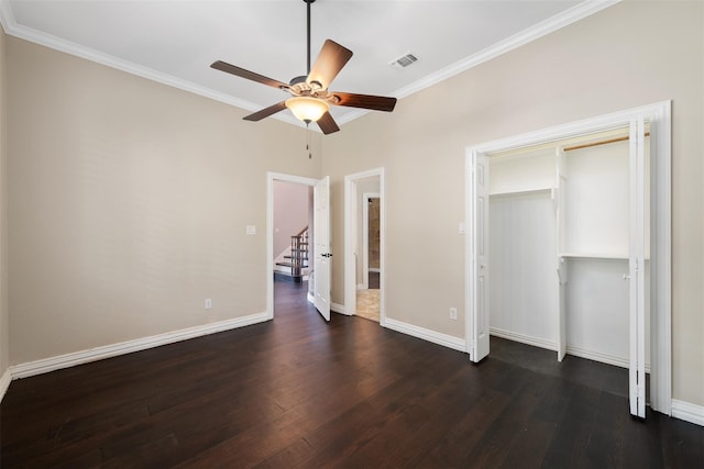 unfurnished bedroom with crown molding, dark wood-type flooring, ceiling fan, and a closet