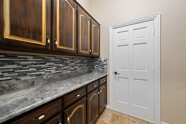 interior space featuring tasteful backsplash and dark brown cabinets