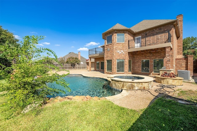 rear view of house with a patio, a balcony, a lawn, a swimming pool with hot tub, and central AC