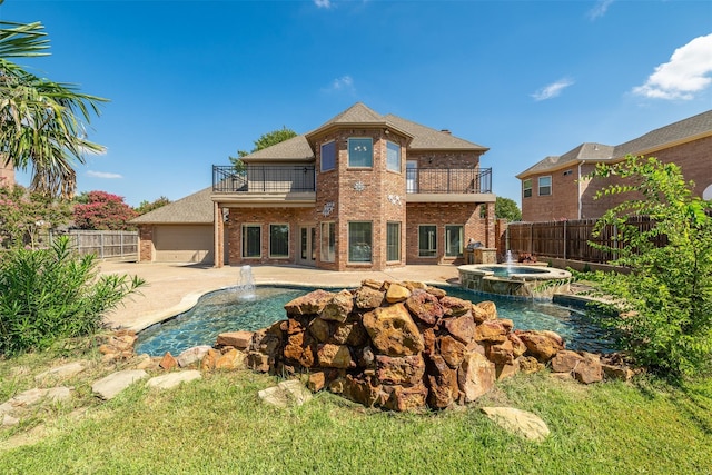 rear view of property with pool water feature, a balcony, a pool with hot tub, and a patio area