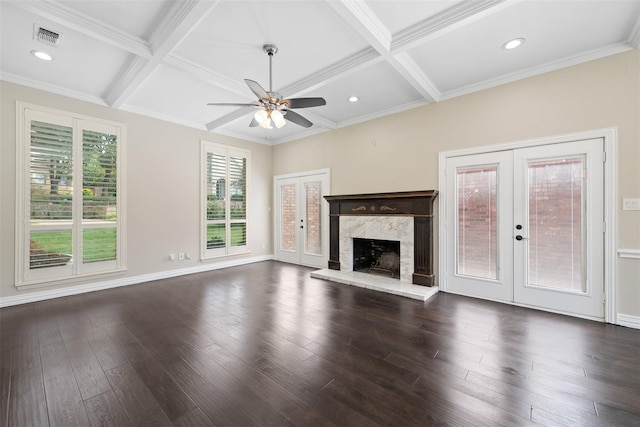 unfurnished living room featuring dark hardwood / wood-style flooring, coffered ceiling, ceiling fan, beam ceiling, and french doors