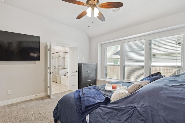 bedroom featuring ensuite bath, vaulted ceiling, light colored carpet, and ceiling fan