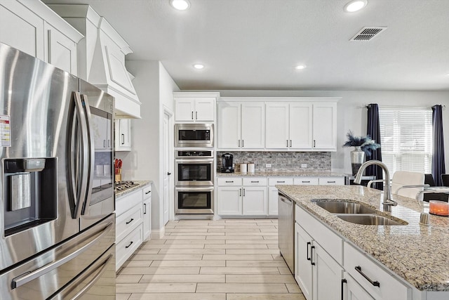 kitchen featuring white cabinets, decorative backsplash, sink, and appliances with stainless steel finishes