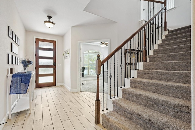 foyer entrance with ceiling fan and light hardwood / wood-style floors