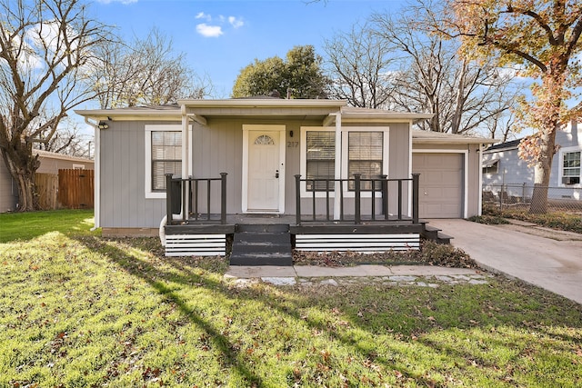 view of front of property featuring a porch, a garage, and a front lawn