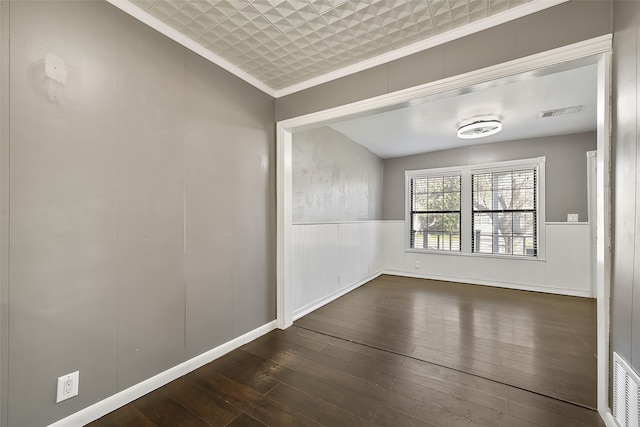 empty room featuring dark hardwood / wood-style floors and ornamental molding