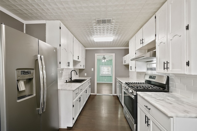 kitchen with ornamental molding, stainless steel appliances, ceiling fan, sink, and white cabinets