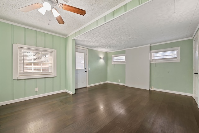 empty room with a textured ceiling, ceiling fan, dark hardwood / wood-style floors, and ornamental molding