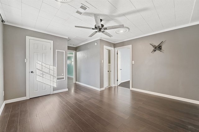 unfurnished bedroom with ceiling fan, dark hardwood / wood-style floors, and ornamental molding