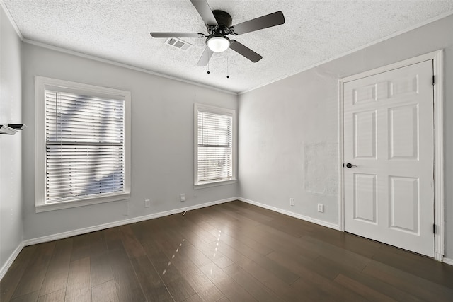 empty room featuring ornamental molding, dark wood-type flooring, ceiling fan, and a textured ceiling