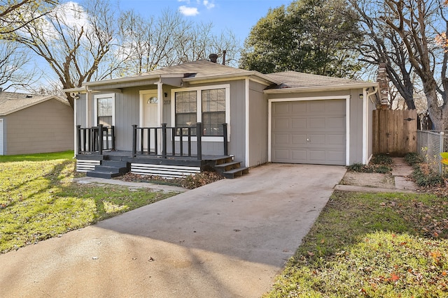 view of front of home featuring covered porch, a front yard, and a garage