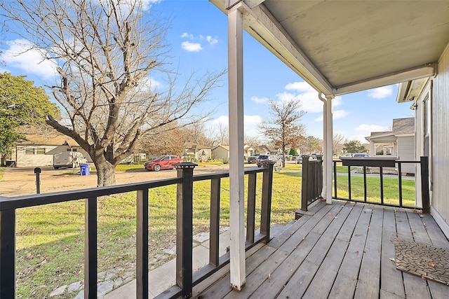 wooden terrace with a porch and a lawn