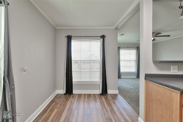 empty room with hardwood / wood-style flooring, a wealth of natural light, and crown molding