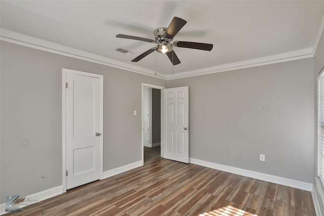 unfurnished bedroom with ceiling fan, crown molding, and dark wood-type flooring