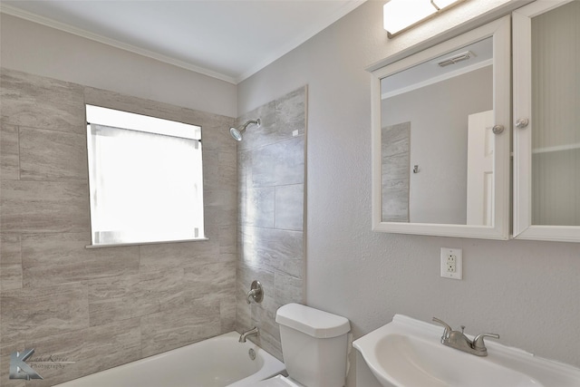 full bathroom featuring tiled shower / bath combo, toilet, and sink