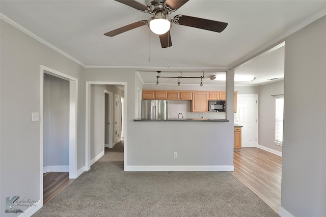 kitchen with light brown cabinetry, ornamental molding, light colored carpet, ceiling fan, and stainless steel refrigerator