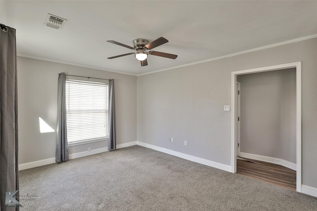 carpeted spare room featuring ceiling fan and ornamental molding