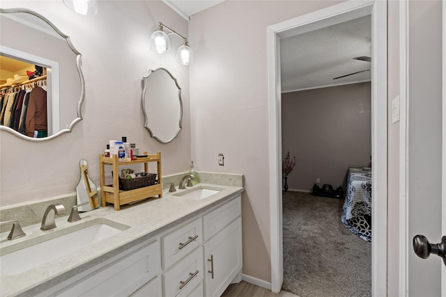 bathroom with vanity, ceiling fan, and a textured ceiling