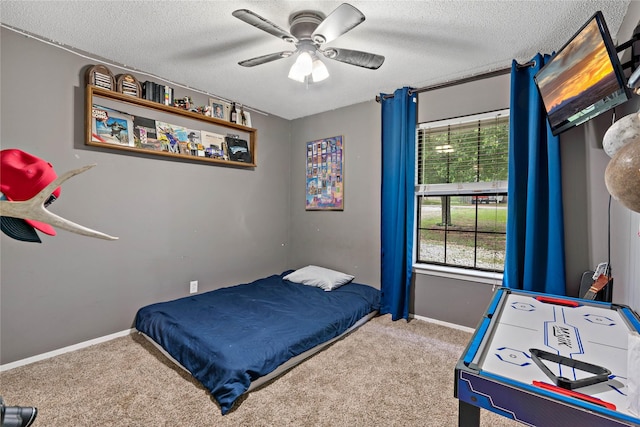 carpeted bedroom featuring ceiling fan and a textured ceiling