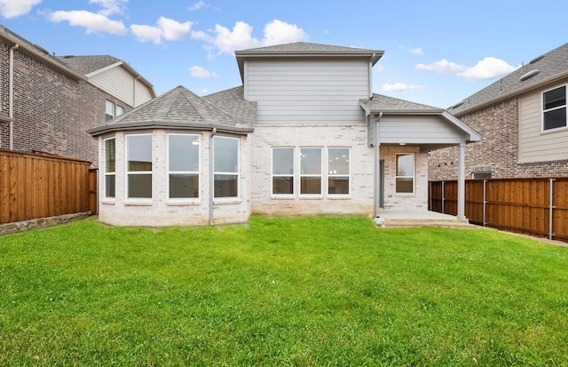 back of property featuring a lawn and a patio area