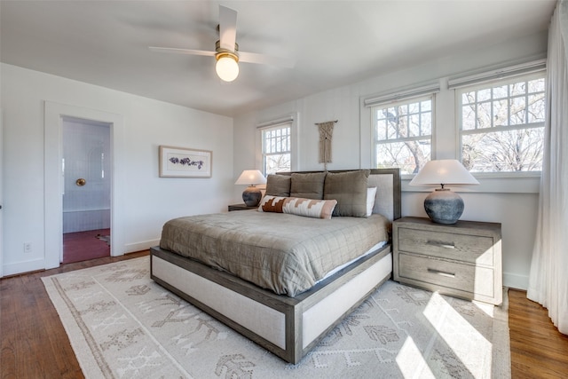 bedroom featuring connected bathroom, ceiling fan, and wood-type flooring