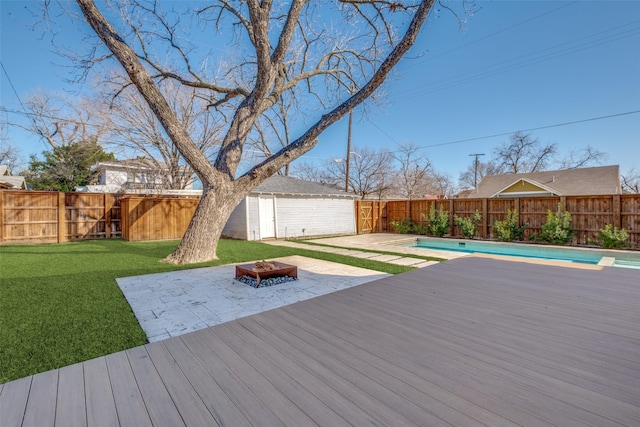 deck with a patio, a yard, a fenced in pool, and a fire pit