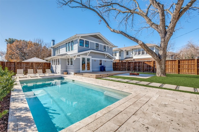 rear view of property with a patio area, french doors, a pool side deck, and an outdoor fire pit