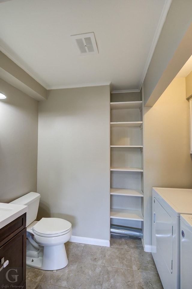 bathroom with washer and clothes dryer, vanity, toilet, and crown molding