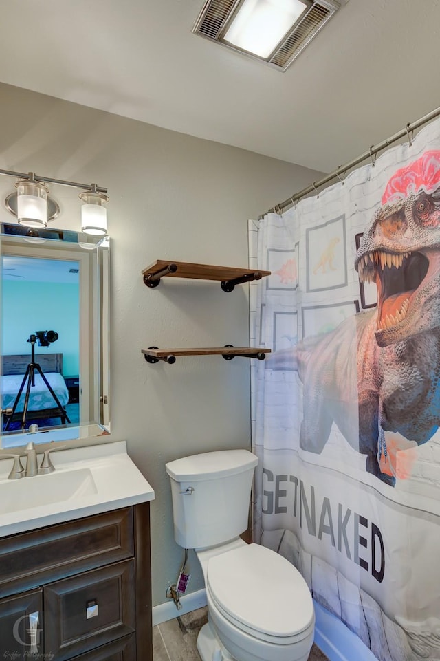 bathroom featuring vanity, toilet, and walk in shower