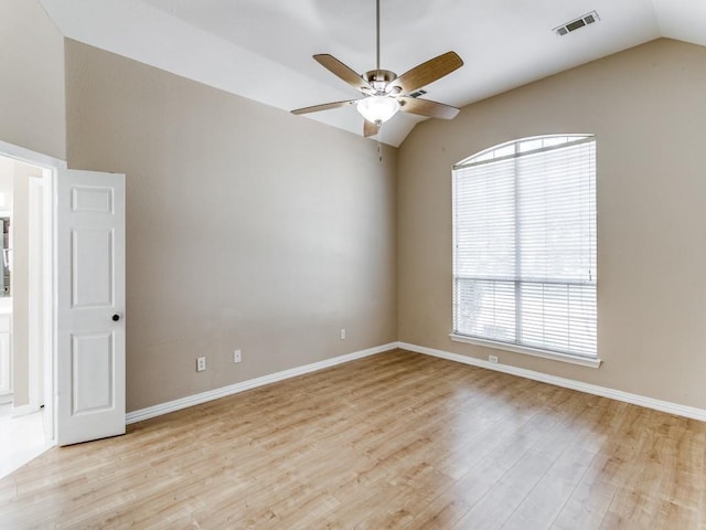 empty room featuring plenty of natural light, light hardwood / wood-style floors, and lofted ceiling