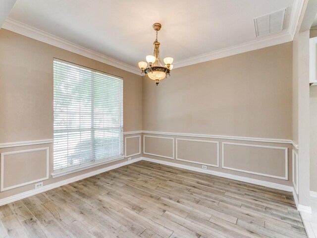 empty room with a notable chandelier and light hardwood / wood-style flooring