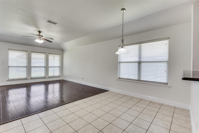 unfurnished room with ceiling fan, light tile patterned flooring, and vaulted ceiling