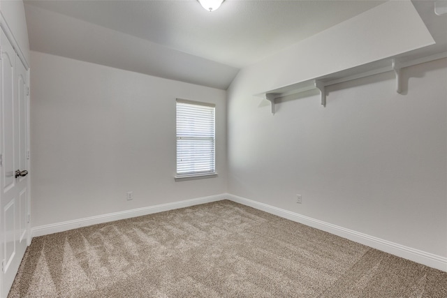 unfurnished room featuring carpet floors and lofted ceiling