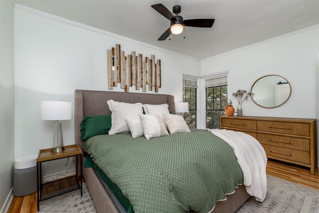 bedroom with crown molding, ceiling fan, and light hardwood / wood-style floors