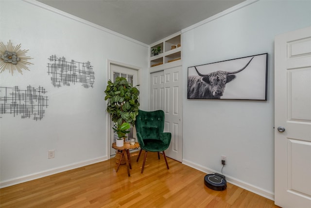 living area featuring ornamental molding and wood-type flooring