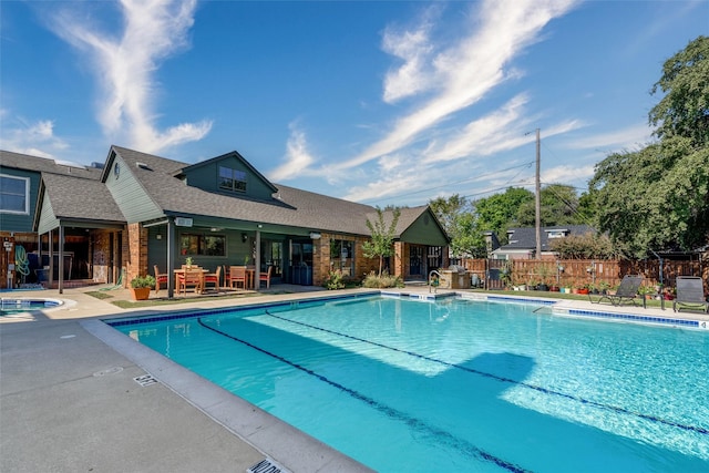 view of swimming pool featuring a community hot tub and a patio