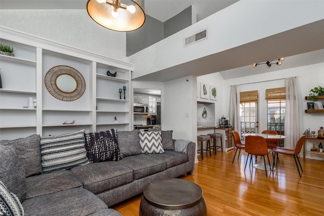 living room with a towering ceiling and hardwood / wood-style floors