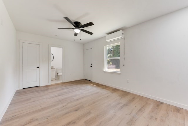 empty room featuring ceiling fan, a wall mounted air conditioner, and light hardwood / wood-style floors