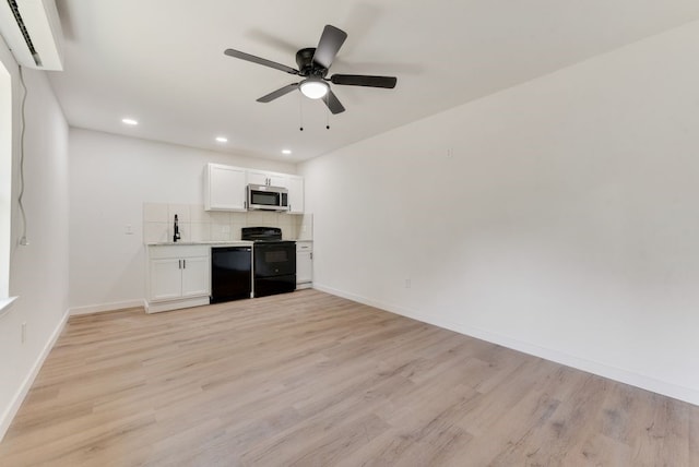 interior space featuring light hardwood / wood-style floors, white cabinets, backsplash, and black appliances