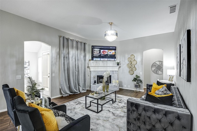 living room featuring a notable chandelier, wood-type flooring, and a fireplace