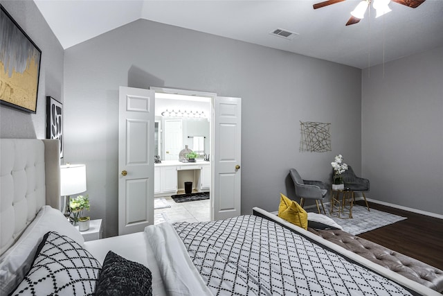 bedroom featuring light wood-type flooring, ceiling fan, lofted ceiling, and connected bathroom