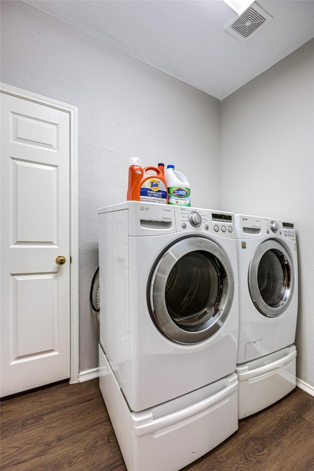 washroom featuring dark hardwood / wood-style flooring and washing machine and dryer