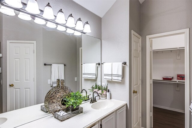 bathroom featuring vanity, lofted ceiling, and hardwood / wood-style flooring