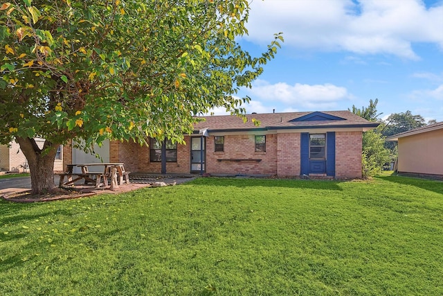 back of property featuring a patio and a lawn