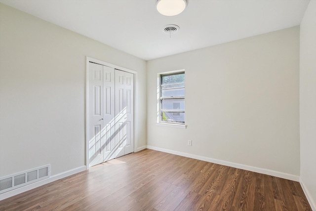 unfurnished bedroom with hardwood / wood-style floors and a closet