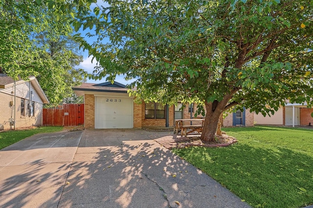 obstructed view of property featuring a garage and a front yard