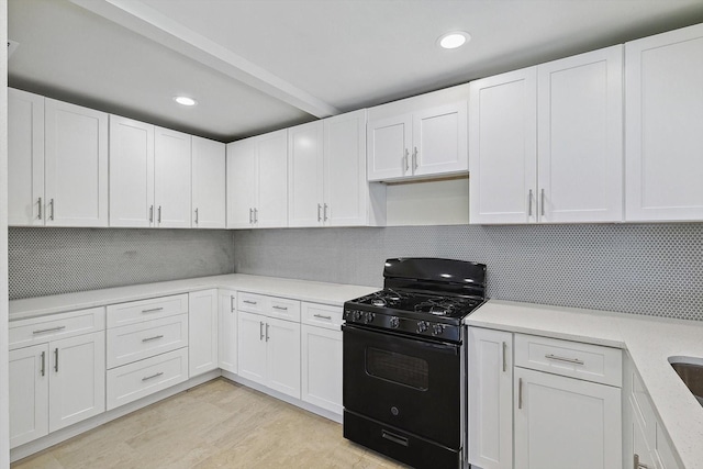 kitchen with white cabinetry, black range with gas cooktop, light hardwood / wood-style flooring, and backsplash