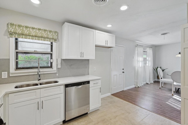 kitchen with white cabinetry, dishwasher, sink, and backsplash