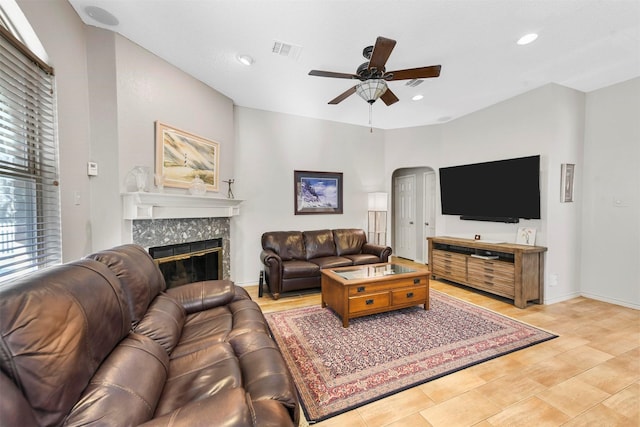 living room featuring ceiling fan and a premium fireplace