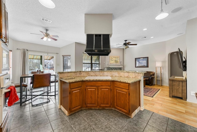 kitchen featuring ceiling fan, a center island, white appliances, and a textured ceiling